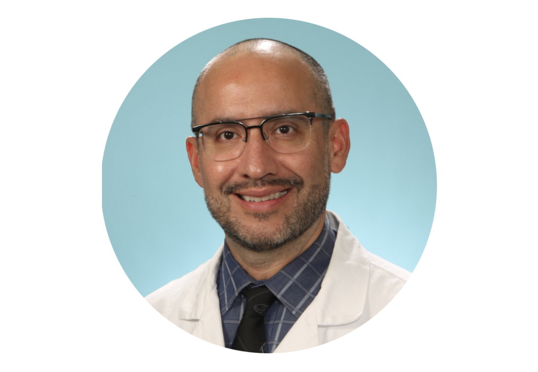 A portrait of Dr. Brian Torres smiling with a white doctor coat.